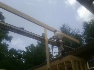 Carpenter setting a ridge beam over a new addition frame — Ice Dam Removal by Roofing Brothers in Saugatuck